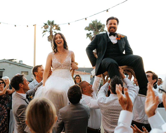 GIF of a wedding couple in Hermosa Beach, California. Couple raised up in chairs by guests